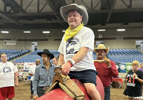 Man riding on imitation bull at the Exceptional Rodeo
