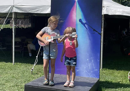 Kids playing with guitar at photo station.